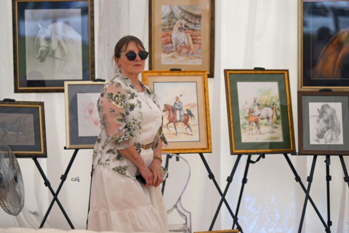 Małgorzata Świertok, the watercolourist whose works decorate the covers of Tarnów catalogues, with her works in the background – Photo by Ewa Imielska-Hebda